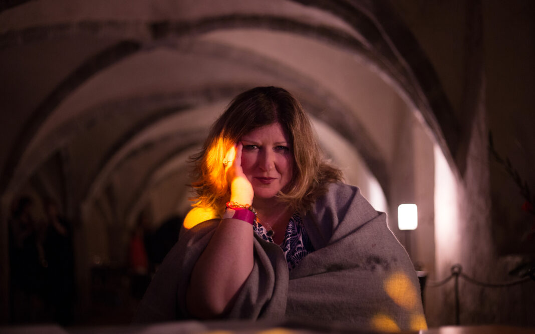 Samantha Mattocks in an old building, resting her chin on her hand