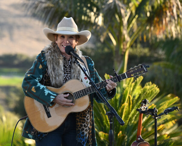 Juni Fisher playing guitar and singing 