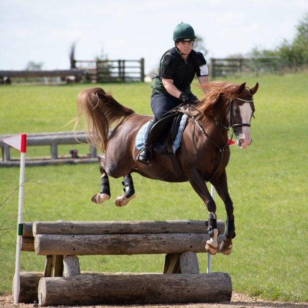 Penny jumping a fence into water at Oxstalls (c) Photography by Shelley