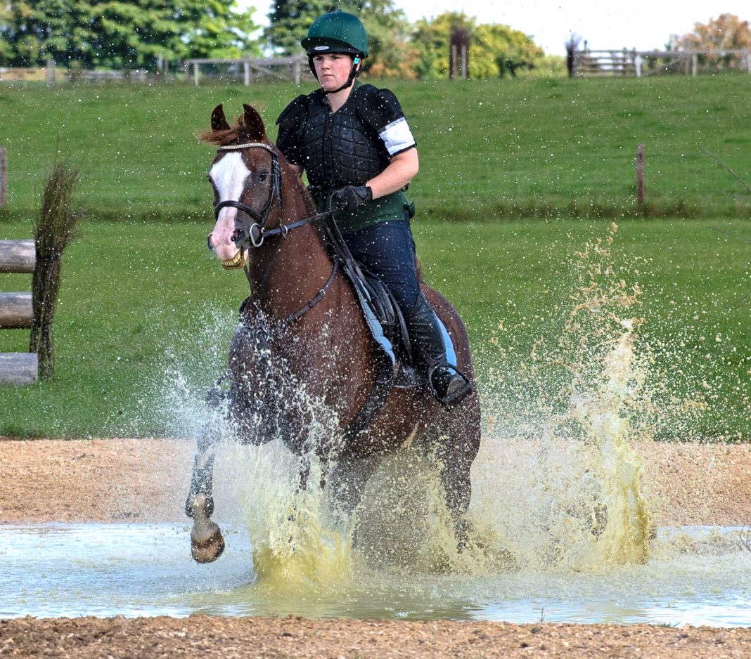 Penny splashing through the water under the watchful eye of Olympian Jonty Evans (c) Photography by Shelley